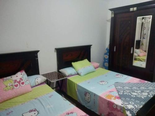 2 nebeneinander sitzende Betten in einem Schlafzimmer in der Unterkunft the flowers apartment in Alexandria