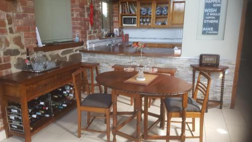 cocina con mesa, sillas y barra en HighRoost Bed & Breakfast accomodation - rural escape, en Red Creek