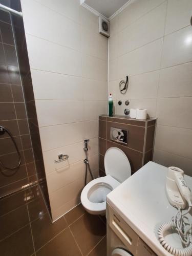 een badkamer met een toilet en een telefoon. bij Sleep and drive cosy in Sarajevo