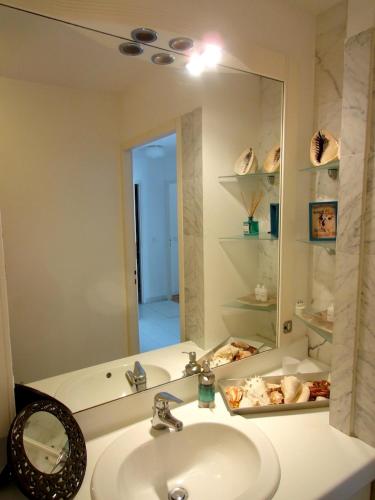une salle de bain avec un lavabo et un miroir dans l'établissement Monaco Stunning Sea Views, Larvotto beach, Terrace, Saint-Roman, à Beausoleil