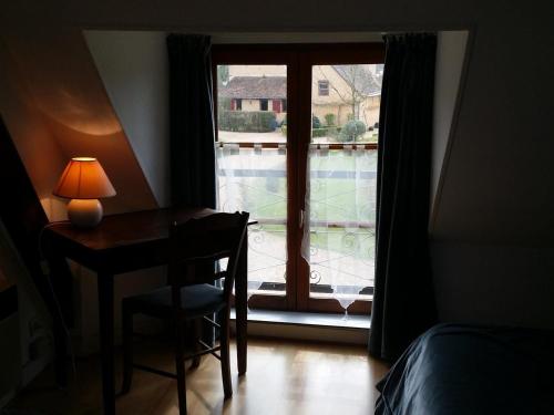 a bedroom with a desk and a window with a table and chair at Gîte Asnières-sur-Vègre, 2 pièces, 2 personnes - FR-1-410-148 in Asnières-sur-Vègre