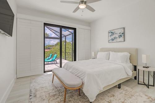 una camera bianca con letto e patio di The Twins Villa a Cape Coral