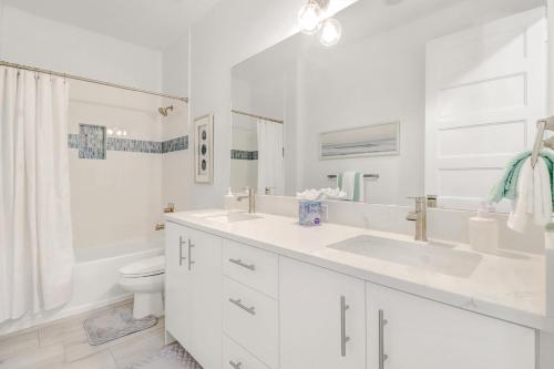 un bagno bianco con lavandino e WC di The Twins Villa a Cape Coral