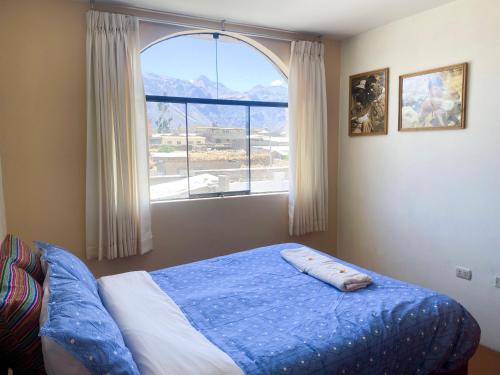 - une chambre avec un lit et une grande fenêtre dans l'établissement Homestay Pachamama, à Cabanaconde