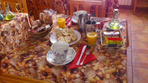 una mesa con comida y zumo de naranja. en Hostal Casa La Picota en Cofiñal