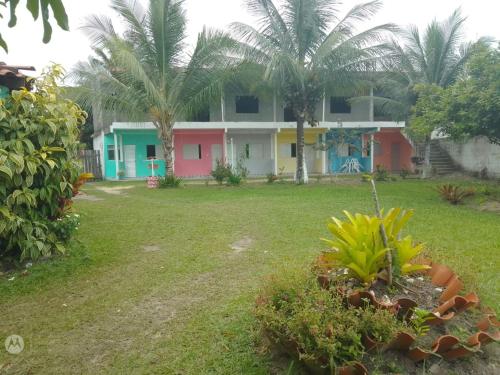 a group of houses with palm trees in a yard at Pousada Praia de Tairu in Armação do Tairu