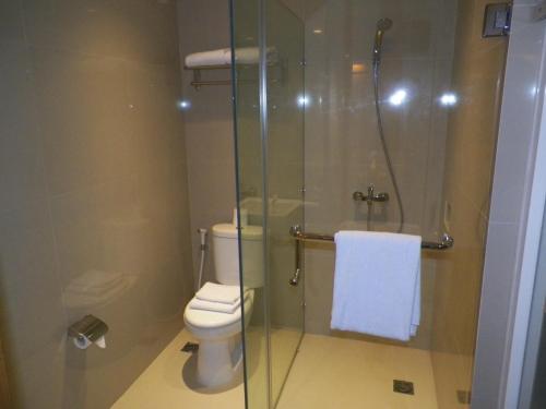 a bathroom with a toilet and a glass shower at Lunara Home Living by Daphna Management in Yogyakarta
