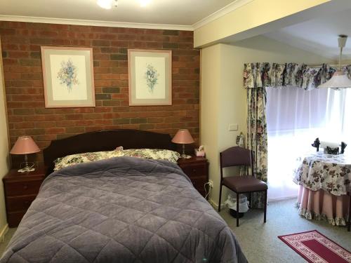 um quarto com uma cama e uma parede de tijolos em Lanaud Farm Stay em Allansford