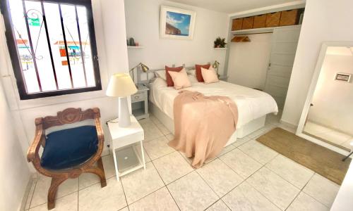 a bedroom with a bed and a chair and a window at Sea View Penthouse with Large Terrace in Los Cristianos