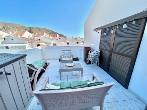 a small patio with a table and chairs on a balcony at Sea View Penthouse with Large Terrace in Los Cristianos