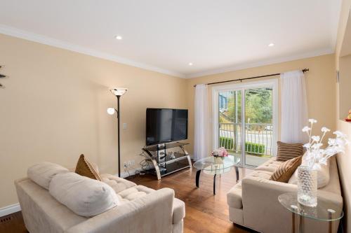 a living room with two couches and a tv at LOVELY 3 bedroom PORT MOODY spacious home 6 people free parking in Port Moody