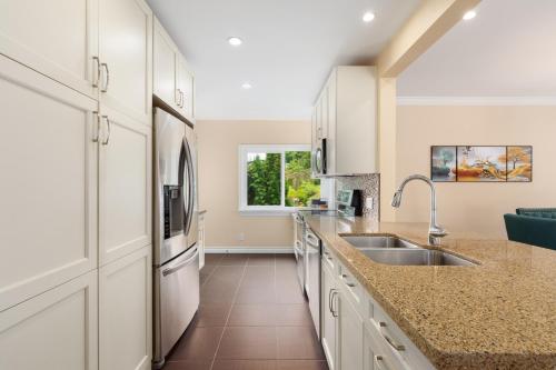 a kitchen with a sink and a refrigerator at LOVELY 3 bedroom PORT MOODY spacious home 6 people free parking in Port Moody