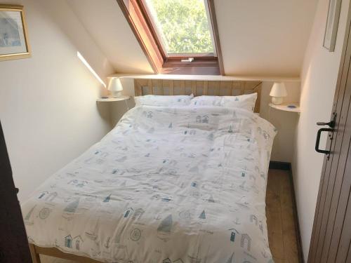 Bett in einem kleinen Zimmer mit Fenster in der Unterkunft Colombo Cottage in Uplyme