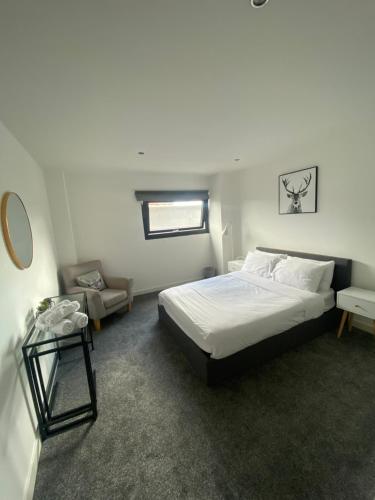 1 dormitorio con 1 cama grande y 1 mesa en SECC&HYDRO BeAUTIFUL 2BR APARTMENT WITH FREE PARKING, en Glasgow