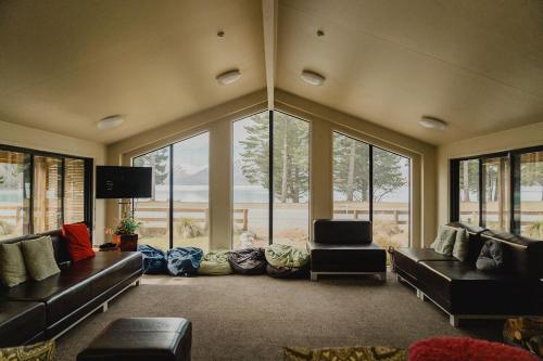 a living room with couches and a large window at Lakes Edge Lodge in Lake Tekapo
