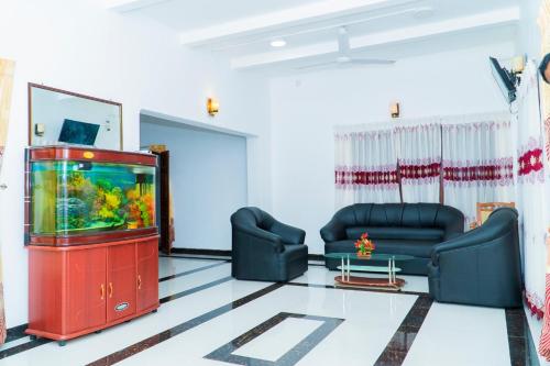 a living room with a fish tank and a tv at St Anne's Hotel & Restaurant in Jaffna