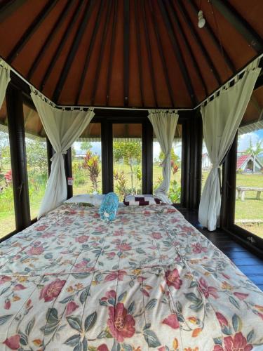 a large bed in a room with windows at Bugo Camp Glamping & Natural Activity in Munduk