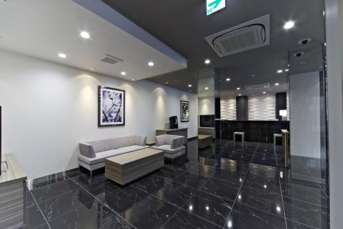 a living room with a couch and a piano at Shizutetsu Hotel Prezio Numazu in Numazu