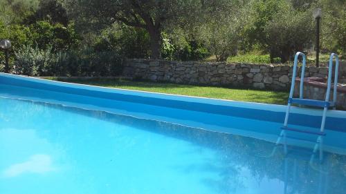 a blue swimming pool with a chair in it at Oasi delle Madonie in Scillato