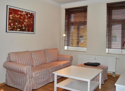 a living room with a couch and a table at Adoreo Apartments & Suites in Leipzig