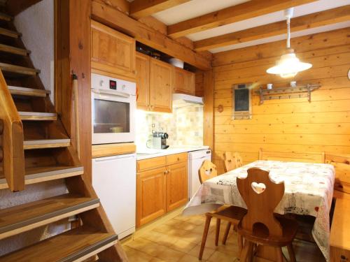 une cuisine avec une table et des chaises dans une cabine dans l'établissement Chalet 2 Chambres Centre-Village, Wi-Fi, Parking, Proche Pistes et Commerces - FR-1-572-234, à Arâches-la-Frasse