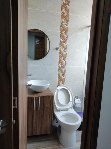 a bathroom with a toilet and a sink and a mirror at Hermoso y Cómodo Apartamento--Excelente Ubicación in San Gil