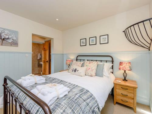 a bedroom with a large bed and a lamp on a night stand at Castlemans Stables East in Sedlescombe