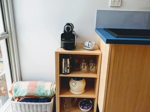 a small wooden shelf with a tea pot on it at Bush meets Beach in Mossy Point