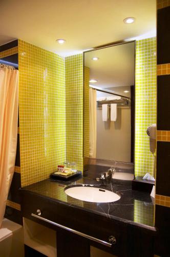 a bathroom with a sink and a mirror at Hotel Gran Puri Manado in Manado