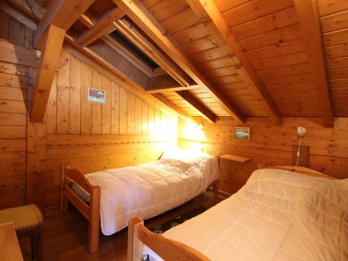 une chambre avec deux lits dans une cabane en rondins dans l'établissement Chalet 2 Chambres Centre-Village, Wi-Fi, Parking, Proche Pistes et Commerces - FR-1-572-234, à Arâches-la-Frasse