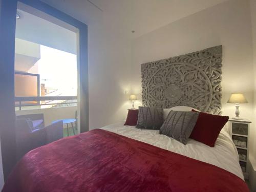 une chambre avec un grand lit avec une grande fenêtre dans l'établissement Sainte-Maxime: Appartement 2 pièces rénové avec terrasse, climatisation et à 2 pas de la plage - FR-1-226-498, à Sainte-Maxime