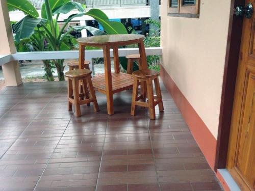 uma mesa e dois bancos sentados num alpendre em Chuanchom Resort em Phatthalung