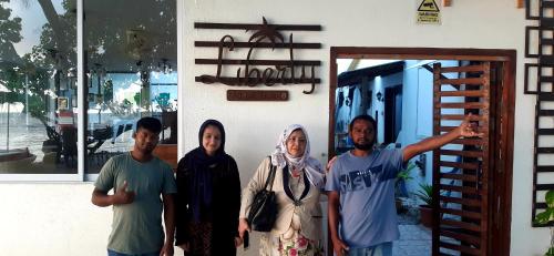 a group of people standing in front of a door at Liberty Guesthouse Maldives in Mahibadhoo