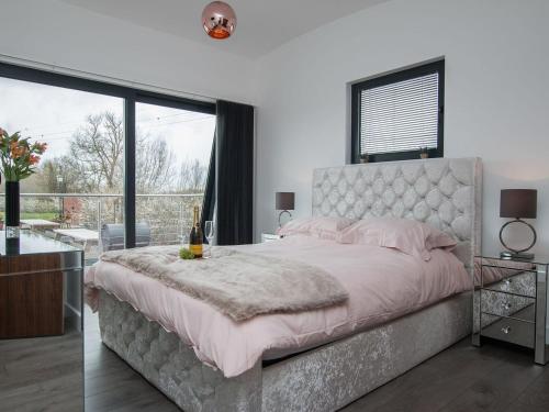 een slaapkamer met een groot bed en een groot raam bij Sunnyside Lodge in Glastonbury