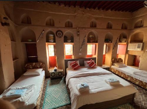 1 dormitorio con 2 camas en una habitación con ventanas en Al Misfah Hospitality Inn, en Misfāh