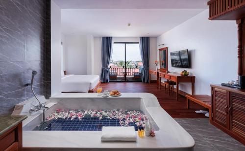 シェムリアップにあるTwo Seasons Siem Reap Hotelのバスルーム(花の咲く大きなバスタブ付)