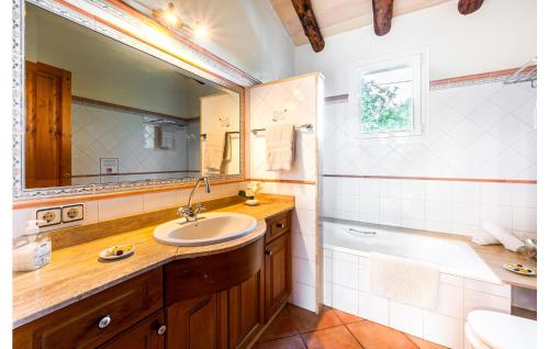 ein Badezimmer mit einem Waschbecken, einer Badewanne und einem Spiegel in der Unterkunft Nice Home In Manacor With House A Mountain View in Manacor