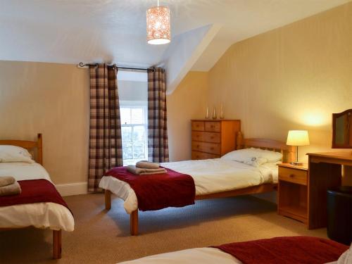 um quarto com 2 camas e uma janela em Bwthyn Ty Mawr em Llandwrog
