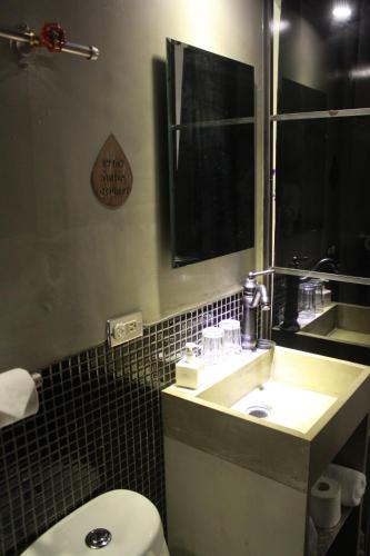 a bathroom with a sink and a toilet and a mirror at 禾裕 北車 Hey!U in Taipei
