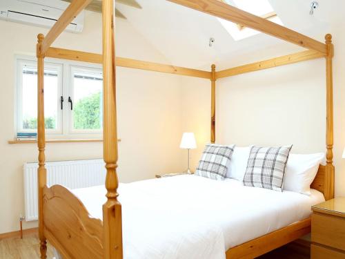 a bedroom with a four poster bed in a room at Kentish Barn Retreat in Chilham