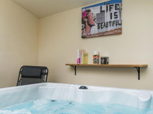 a bath tub in a room with a sign on the wall at Kentish Barn Retreat in Chilham