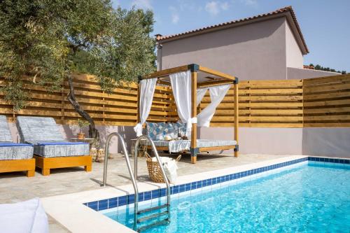 a pool with a gazebo next to a house at Skiathos Avaton Suites & Villas, Philian Hotels and Resorts in Megali Ammos