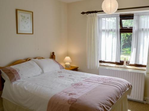 una camera con un letto e due finestre di Forge Cottage a Happisburgh