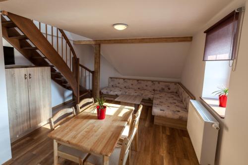 a room with a table and chairs and a staircase at Houda Bouda - Penzion & Apartmány in Boží Dar