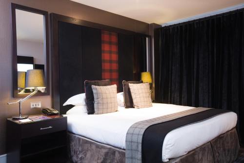 Habitación de hotel con cama grande y espejo en Malmaison Aberdeen, en Aberdeen