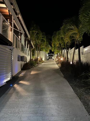 a street with palm trees and a building at night at GREEN LORD DOMAINE - Lodges Piscine & Spa - Bar & Lounge - Restaurant gastronomique in Lamentin