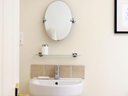 a bathroom with a sink and a mirror on the wall at The Bothy At Fordcombe in Speldhurst