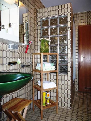 a bathroom with a sink and a green tub at Ferienwohnung Will in Walkenried