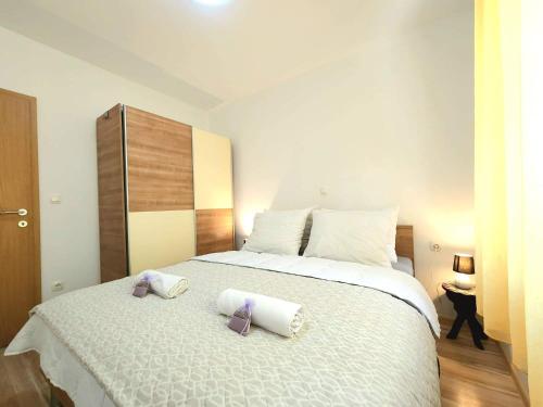 ein Schlafzimmer mit einem großen Bett mit zwei Handtüchern darauf in der Unterkunft IVA apartments in Šilo