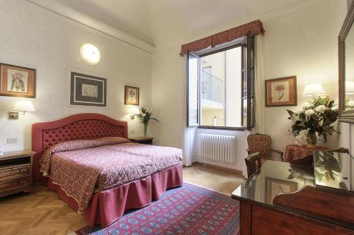 a bedroom with a bed and a window at Hotel Alessandra in Florence